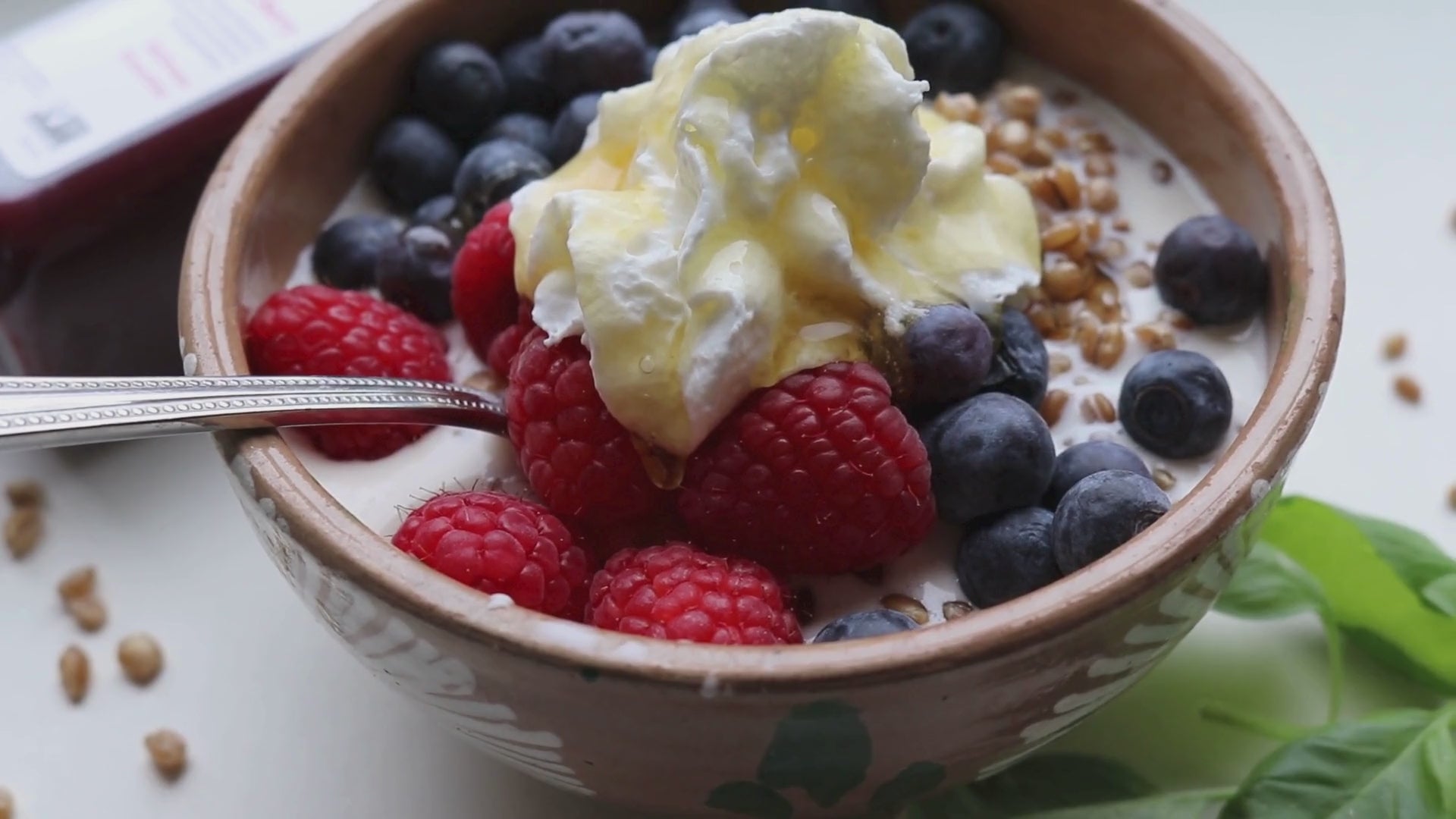 Load video: Video of a bowl of creamed wheat berries with blueberries, raspberries, cream and honey. Video plans around bowl and presents a logo of plaingrains. subtitles are presented that state &quot;Better for Your Gut, Better for You.&quot;